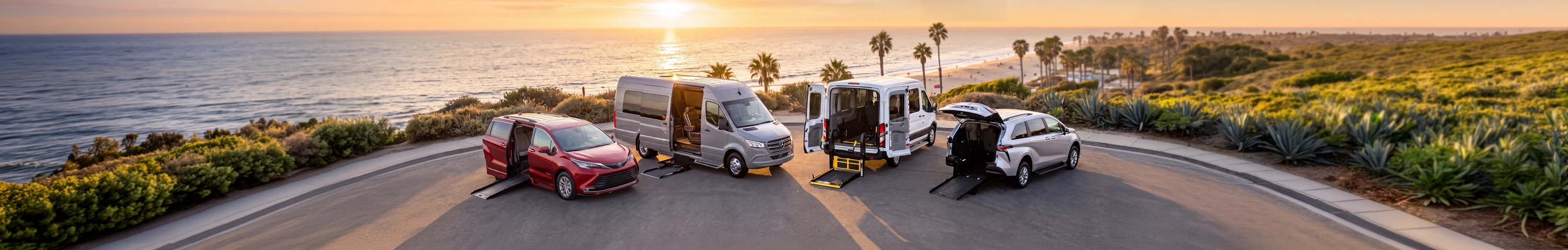 Four wheelchair-accessible vehicles parked on a coastal road at sunset